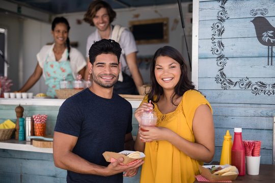 Smiling couple standing with snacks and juice