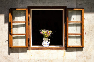 Open window frame with the bouquet of meadow flowers