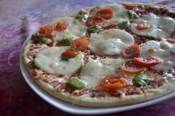 Pizza artisanale à la mozzarella, aux tomates et au pesto