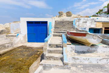 Blue boat house (sirmata) in Mandrakia village on the coast of Milos island, Cyclades, Greece. © vivoo