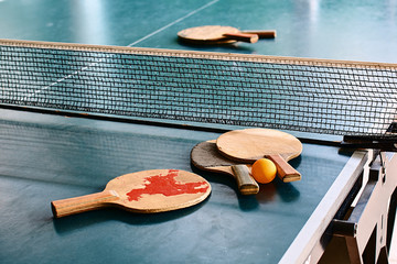 Old used table tennis rackets on the game table