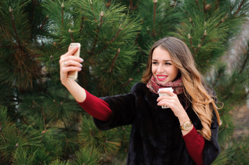 girl doing selfie in autumn park