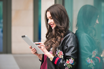 young girl using tablet in the street, hipster style, outdoor portrait, happy face