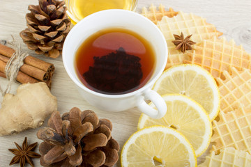 Cup of tea with honey, pinecone, badian, ginger, waffles and cinnamon