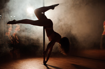Obraz na płótnie Canvas young hot woman in sexy lingerie performs sensual pole dance. Go-go dancer
