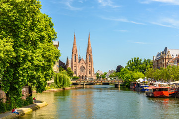 Fototapeta na wymiar View of a canal of Strasbourg witha a gothic church in background
