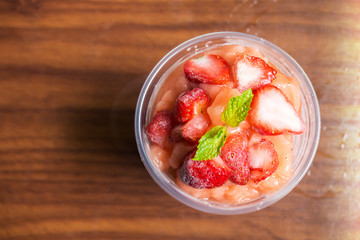 Strawberry smoothies in plastic cup. Refreshment healthy drink. Top view.