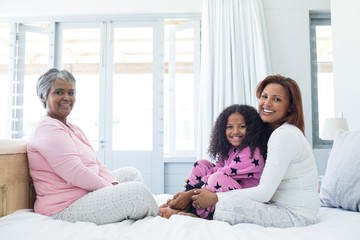 Happy family sitting on bed in bed room