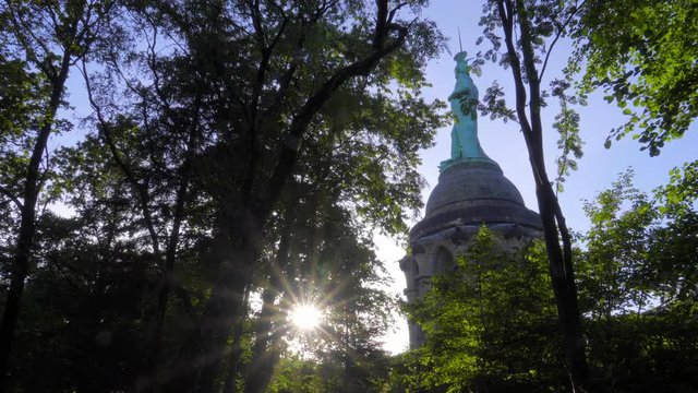 Hermannsdenkmal im Teutoburger Wald gefilmt im Gegenlicht durch den Wald