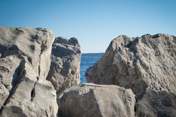 View of blue sea and sky through the big white stone