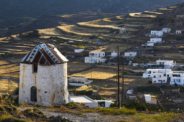 Old windmill and Chora village on Kimolos island in Greece.
