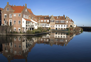Fototapeta na wymiar Old houses reflecting in the water in the small Dutch harbor town of Enkhuizen