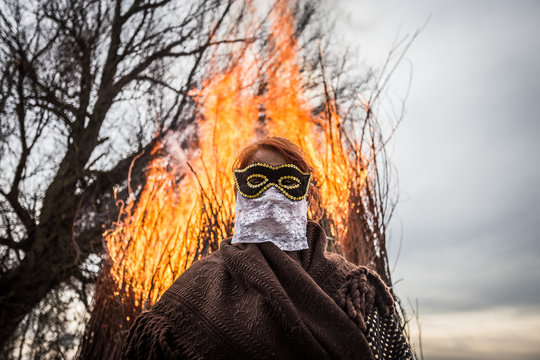 Woman in front of a huge fire during Buso festivities