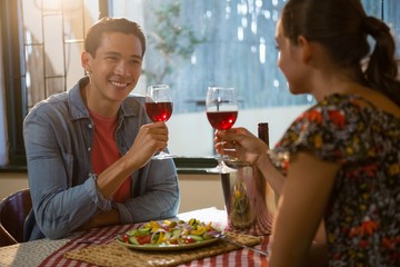 Smiling man with friend having red wine
