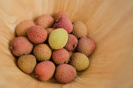 lychee fruit in a wooden bowl, different colors