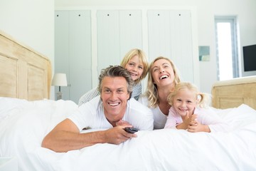 Happy family watching television in the bed room
