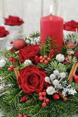 Christmas decoration with red roses, fir, brunia and cinnamon sticks.