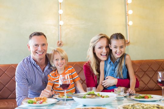 Portrait Of Cheerful Family With Children At Restaurant