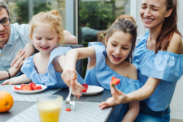 Happy family eating fresh fruit breakfast