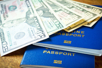 Fototapeta premium Dollars and two blue passports for travel on wooden table, close-up