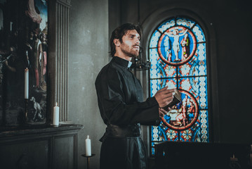 Priest reading and praying in the church