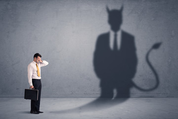 Fototapeta premium Business man looking at his own devil demon shadow concept