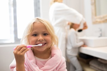 Girl brushing teeth in bathroom