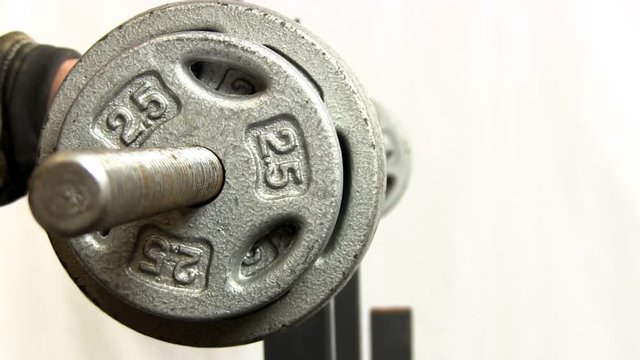 Sliding weights onto barbell and securing with screw nut