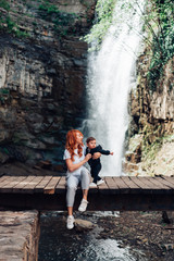 Mom and little son are sitting on the bridge
