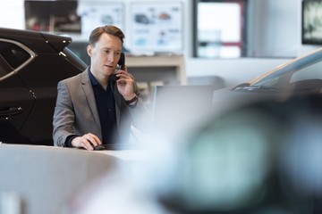 Car salesperson talking on landline phone