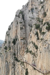 Hikers walking along the wooden walkways of the gorge of Los Gaitanes, in the Caminito del Rey, Malaga, Spain