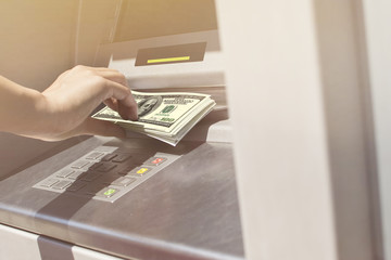 Close-up of a woman's hands using an ATM machine to take some cash. Shopping spree.