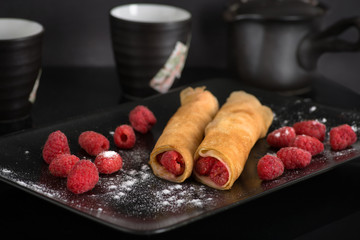 on a plate two pancakes with raspberry lie