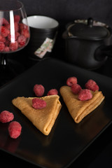 on a plate two pancakes with raspberry lie