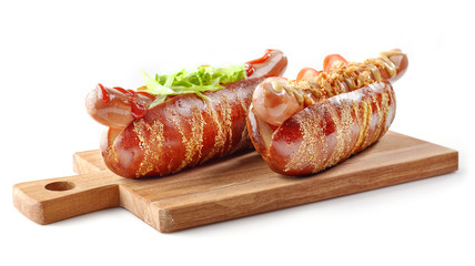 two hotdogs on wooden cutting board