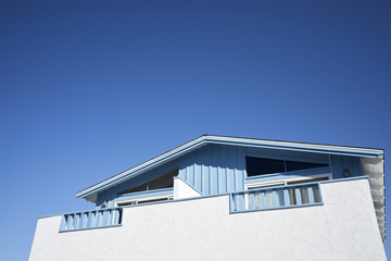 White & baby blue wood and plaster bungalow; expansive sky