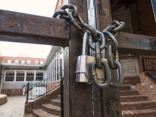 padlock and chain on gate in front of a business establishment's courtyard
