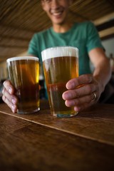 Male bartender serving beer