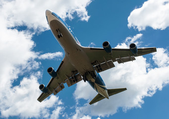The plane on a background of blue sky and white clouds.
