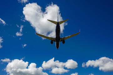 The plane on a background of blue sky and white clouds.
