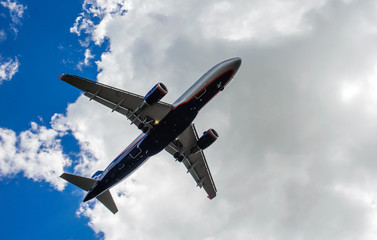 The plane on a background of blue sky and white clouds.