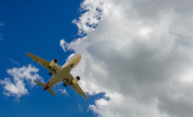 The plane on a background of blue sky and white clouds.
