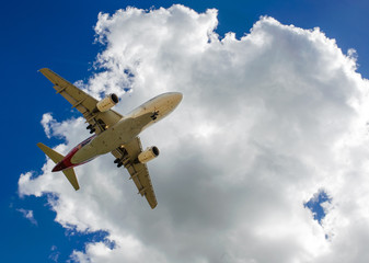 The plane on a background of blue sky and white clouds.