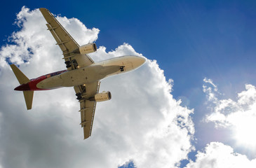 The plane on a background of blue sky and white clouds.