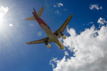 The plane on a background of blue sky and white clouds.