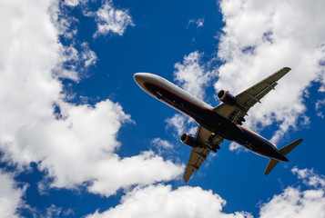 The plane on a background of blue sky and white clouds.