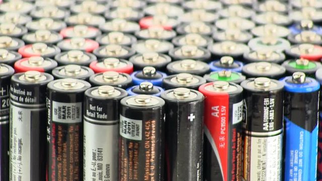 Large collection of AAA batteries standing on end rotating slowly