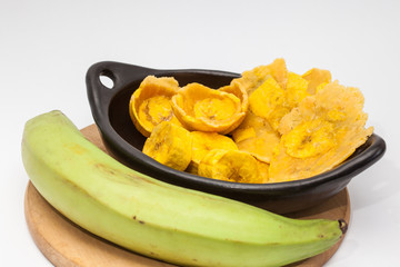 Raw plantain cups, patacones and pieces on white background