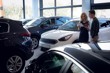 Saleswoman reading brochure while standing by customer