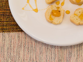Healthy and diet food, close-up of  small slices of toast with honey, on striped plate on table with cotton towel